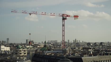 Baukran-Mit-Last,-Der-Sich-Während-Der-Bau--Und-Reparaturarbeiten-über-Die-Stadt-Paris-Bewegt,-4K-30fps