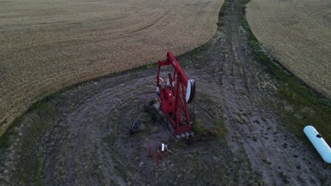 Red-oil-pump-jack-working-in-the-countryside-of-Alberta