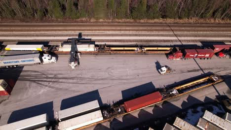 Aerial-drone-view-over-trucks-and-loading-machine-in-containers-cargo-zone,-Vancouver-in-Canada