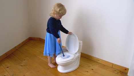 Happy-child-cleaning-a-potty-toilet-with-a-brush