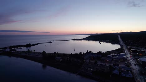Drone-shot-of-a-sunset-in-Grand-Marais,-MN-showing-the-large-boat-harbor