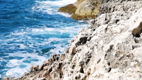 Sea-water-foam-after-waves-hitting-rocky-cliffs-of-Malta-coastline,-static-view
