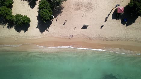 DRONE-SHOT-OF-CRYSTAL-CLEAR-WATER-BEACH-ZOOM-IN
