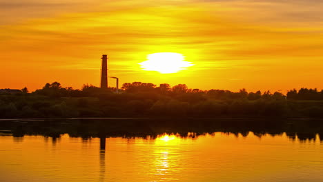 Statische-Ansicht-Des-Sonnenuntergangs-Im-Zeitraffer-über-Einem-Industriegebiet-Neben-Einem-Gewässer-Am-Abend