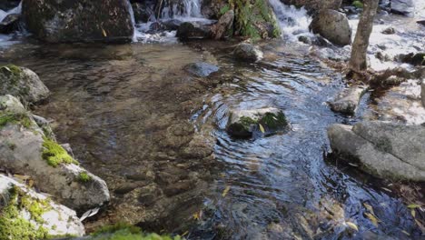 Zuflussreicher-Fluss-Mit-Flachem-Wasser,-Das-Entlang-Des-Baches-Plätschert,-Wo-Einige-Felsen-Einen-Kleinen-Wasserfall-Bilden