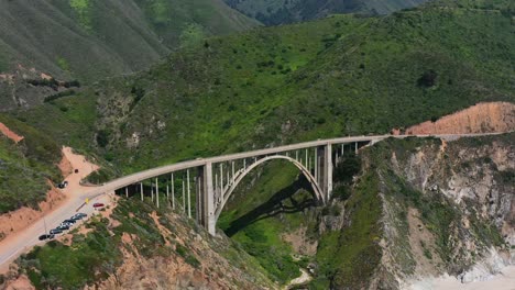 Aerial-drone-of-Bixby-Creek-Bridge-alongside-the-long-Route-1-coastal-road-of-Big-Sur-California-on-a-sunny-summer-day