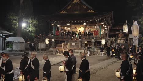 Santuario-Hachiman-En-La-Prefectura-De-Shiga,-Sacerdotes-En-Cámara-Lenta-Caminando-Por-La-Noche