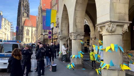 Slow-motion-shot-of-german-police-watching-demonstration-against-Putin-in-historic-town---Flags-of-ukraine-for-freedom-against-russia