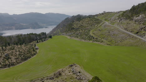 Drone-shot-flying-over-green-fields-and-farmland-in-mountains-of-Norway