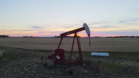 Ein-Herrlicher-Sonnenuntergang-Hinter-Einer-Roten-Ölpumpe-In-Den-Kanadischen-Prärien