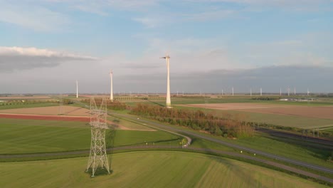 Blick-Auf-Den-Verkehr-Entlang-Eines-Windparks-Mit-Rotierenden-Turbinen-In-Flevoland,-Niederlande