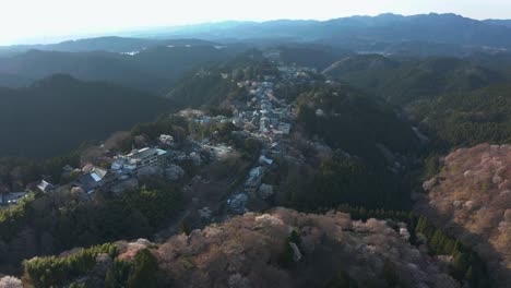 4k-Aerial-Tilt-Reveal-of-Yoshino,-Mountain-Village-and-Sakura