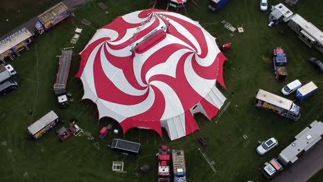 Planet-circus-daredevil-entertainment-colourful-swirl-tent-and-caravan-trailer-ring-aerial-view-descending-Birdseye