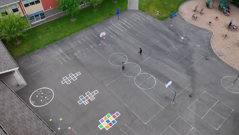 Aerial-shot-of-kids-shooting-hoops-at-an-elementary-school-after-hours
