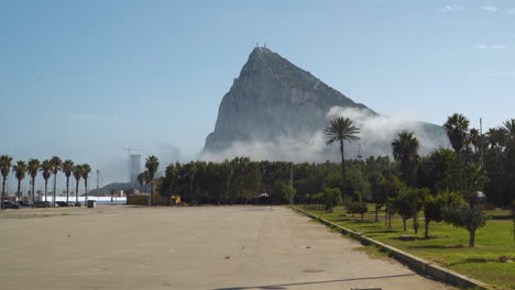 Felsen-Des-Berges-Gibraltar,-Umgeben-Von-Rauchwolken-Und-Palmen