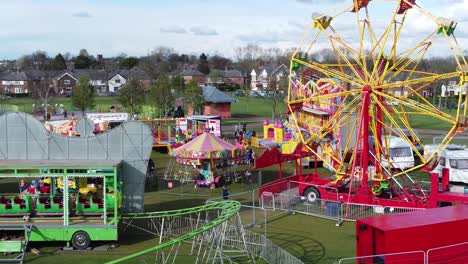 Small-town-colourful-fairground-Easter-holidays-funfair-rides-in-public-park-aerial-view