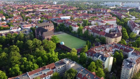 Green-soccer-field-in-the-middle-of-the-capital-of-Germany-Wonderful-aerial-view-flight-rising-up-drone-footage
of-Berlin-Friedenau-Summer-2022