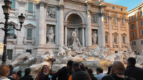Group-of-tourist-visiting-famous-Trevi-Fountain-and-taking-selfies-with-camera-in-Rome