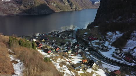 Looking-down-hillside-at-vi-small-remote-village-Undredal-by-the-sea---Aerial-Norway-at-winter-sunrise