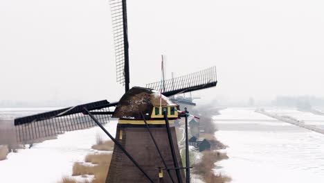 Iconic-Dutch-windmills-in-snowy-landscape,-Kinderdijk,-Netherlands