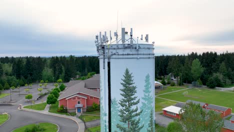 Drone-shot-of-a-water-tower-with-technology-mounted-to-the-top-for-broadcasting