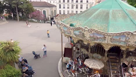 Aufnahme-Des-Berühmten-Karussells-Von-Montmartre,-Das-Sich-Mit-Kind-Und-Eltern-Dreht,-Paris,-Frankreich