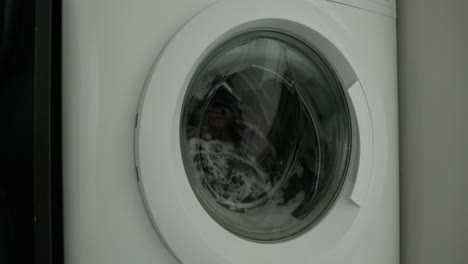 Close-Up-Pan-Right-of-a-Washing-Machine-Washing-Clothes