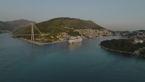 AIDNova-Cruise-Ship-In-Dubrovnik-Croatia-Port-With-Seaside-Town-Views,-Aerial-5K-Drone