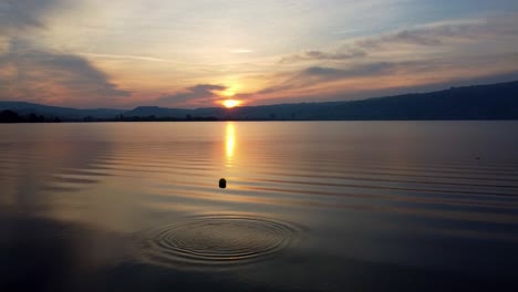 Sun-rise-mirroring-in-the-lake-passing-the-diving-platform-on-the-right