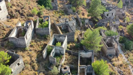macro-aerial-of-the-abandoned-buildings-left-in-ruins-in-the-famous-Kayakoy-village-ghost-town-in-Fethiye-Turkey-on-a-sunny-summer-day