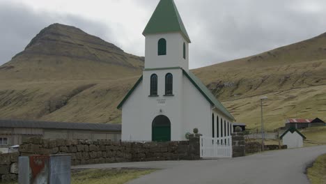 Wide-Tilt-Down-of-a-Church-in-Gjogv,-Faroe-Islands