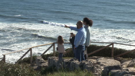 A-group-of-people-watching-the-sea-and-the-stunning-landscape-of-the-city,-at-Cabo-Mondego-viewpoint,-Figueira-da-Foz