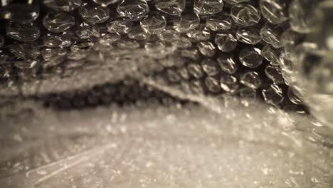pulling-out-of-a-bubble-wrap-bag,-top-of-the-bag-flutters-slightly,-focused-on-the-top-third-of-the-bag