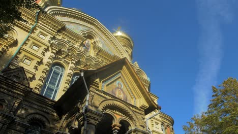 View-of-orthodox-St-Nicholas-Naval-Cathedral-golden-domes-and-crosses-on-blue-sky-in-sunny-autumn-day-at-Karosta,-Liepaja,-pan-right-wide-shot