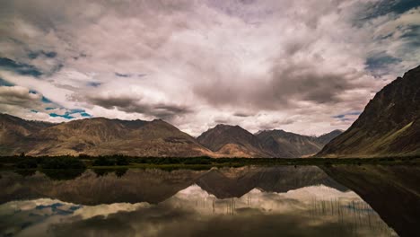 Cloud-formations-over-mountain-tops-reflected-in-lake,-Nubra-Valley,-Ladakh,-India