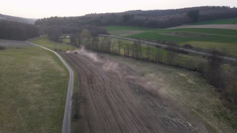 Ein-Staubiges-Braunes-Feld,-Das-Während-Eines-Sonnenuntergangs-In-Deutschland-Von-Einem-Bauerntraktor-Vorbereitet-Wird