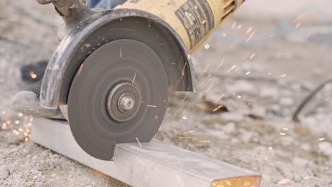 Handheld-shot-of-circular-electric-saw-cutting-metal-surface-with-sparks