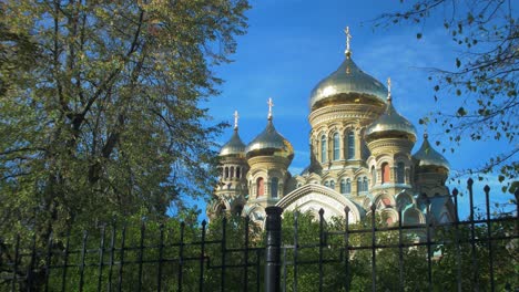 View-of-orthodox-St-Nicholas-Naval-Cathedral-golden-domes-and-crosses-on-blue-sky-in-sunny-autumn-day-at-Karosta,-Liepaja,-wide-shot