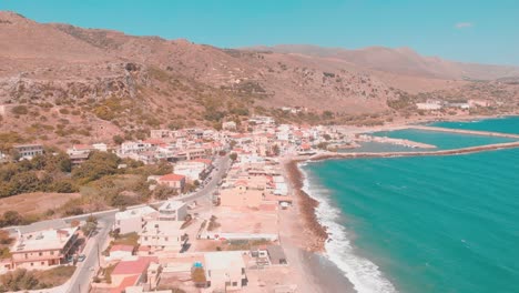 Drone-flying-over-small-town-i-Greece-right-by-the-water