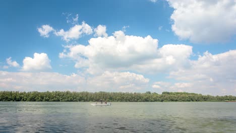 4K-Video-Zeitraffer-Der-Donau-Mit-Fischerboot-Und-Erstaunlichen-Wolken-Am-Blauen-Himmel