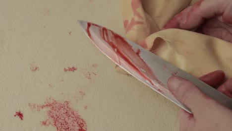 Bloody-hand-of-criminal-murderer-wiping-blood-of-a-knife-after-stabbing