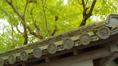 Nahaufnahmen-Traditioneller-Dachpaneele-Mit-Grünen-Momiji-Blättern-Im-Hintergrund-In-Kyoto,-Japan,-Sanfte-Beleuchtung-4K