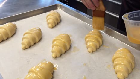 A-Baker-painting-Egg-wash-on-to-croissants-that-will-be-baked-in-a-cafe