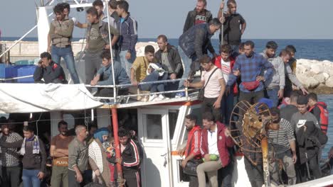 Ein-Boot-Voller-Illegaler-Einwanderer-Aus-Syrien,-Darunter-Männer,-Frauen-Und-Kinder,-Wartet-Hungrig-Und-Müde,-Während-Die-Hafenpolizei-Das-Boot-An-Land,-Latchi-Polis-Chrysochou,-Zypern,-Eskortiert