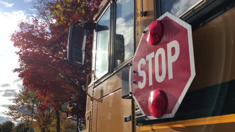 School-bus-back-to-school-autumn-leaves-stop-signal-for-student-transportation