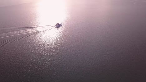 Aerial-speed-boat-chasing-and-following-by-the-drone-at-golden-hour-sunrise