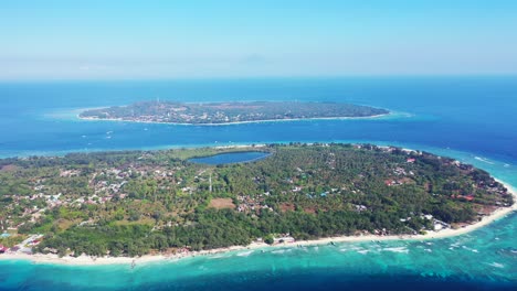 aerial-panorama-of-Gili-islands-in-the-blue-deep-ocean,-natural-saltwater-pool-and-palms