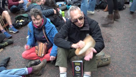 An-older-couple-play-music-during-the-Extinction-Rebellion-protests-in-London,-UK