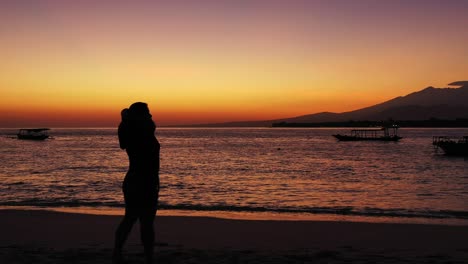 philippines,-worried-woman-with-the-hands-on-her-hand-standing-on-the-sandy-beach-during-the-sunset