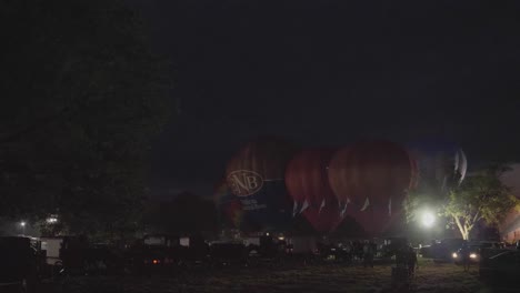 Heißluftballon-Festival-In-Der-Nacht,-Bei-Dem-Propan-Abgefeuert-Wird-Und-In-Einer-Sommernacht-Ein-Nächtliches-Leuchten-Erzeugt